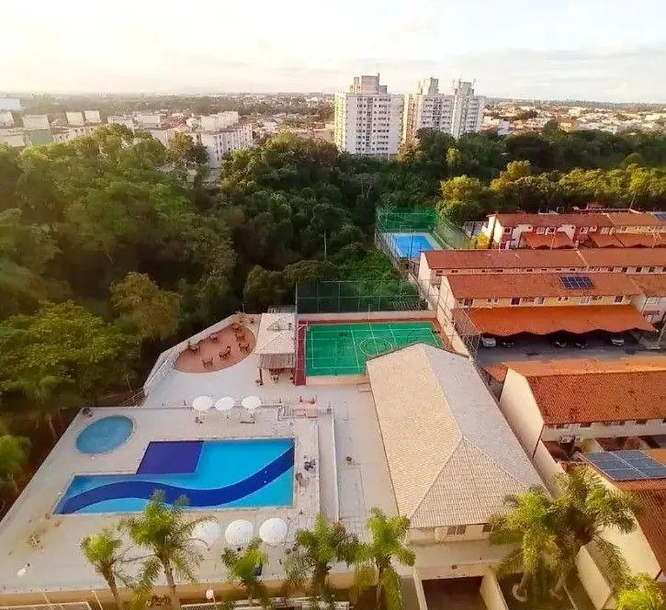 Vista aérea ao entardecer sobre a região de Laranjeiras, na Serra — telhados, área de lazer e o horizonte da Grande Vitória